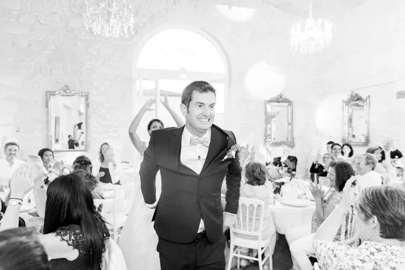 Groom making his entrance into the reception hall, black and white