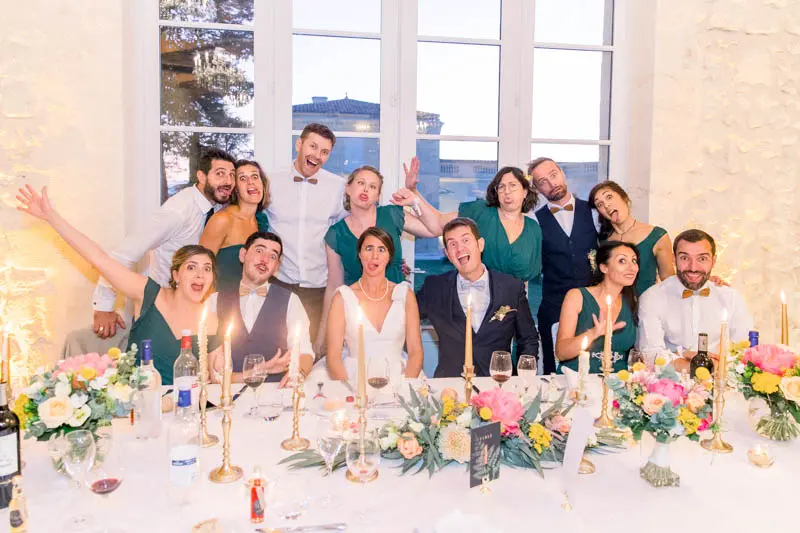 Couple and guests posing happily at the top table during dinner
