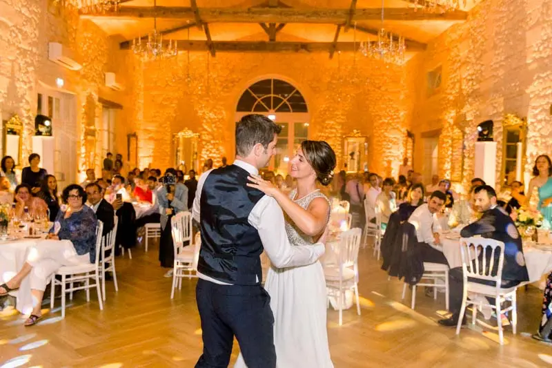 Couple's first dance in the golden-lit reception hall