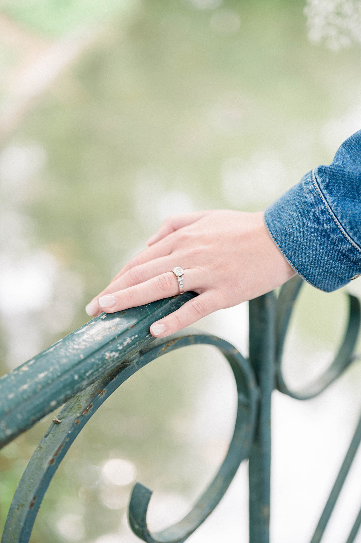 Tamara's hand with her engagement ring on the wrought-iron railing