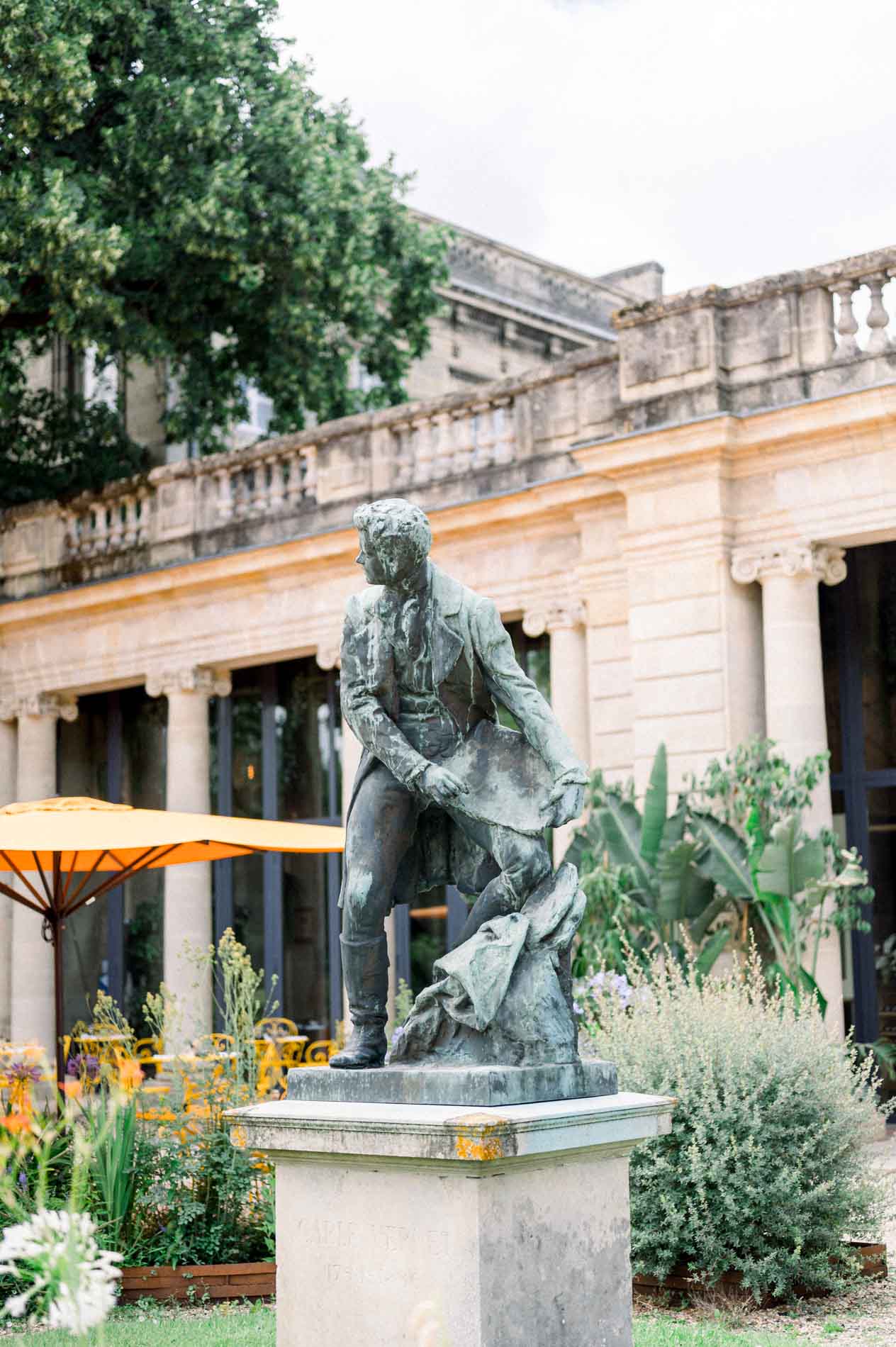 Bronze statue before the colonnaded gallery of the Jardin Public