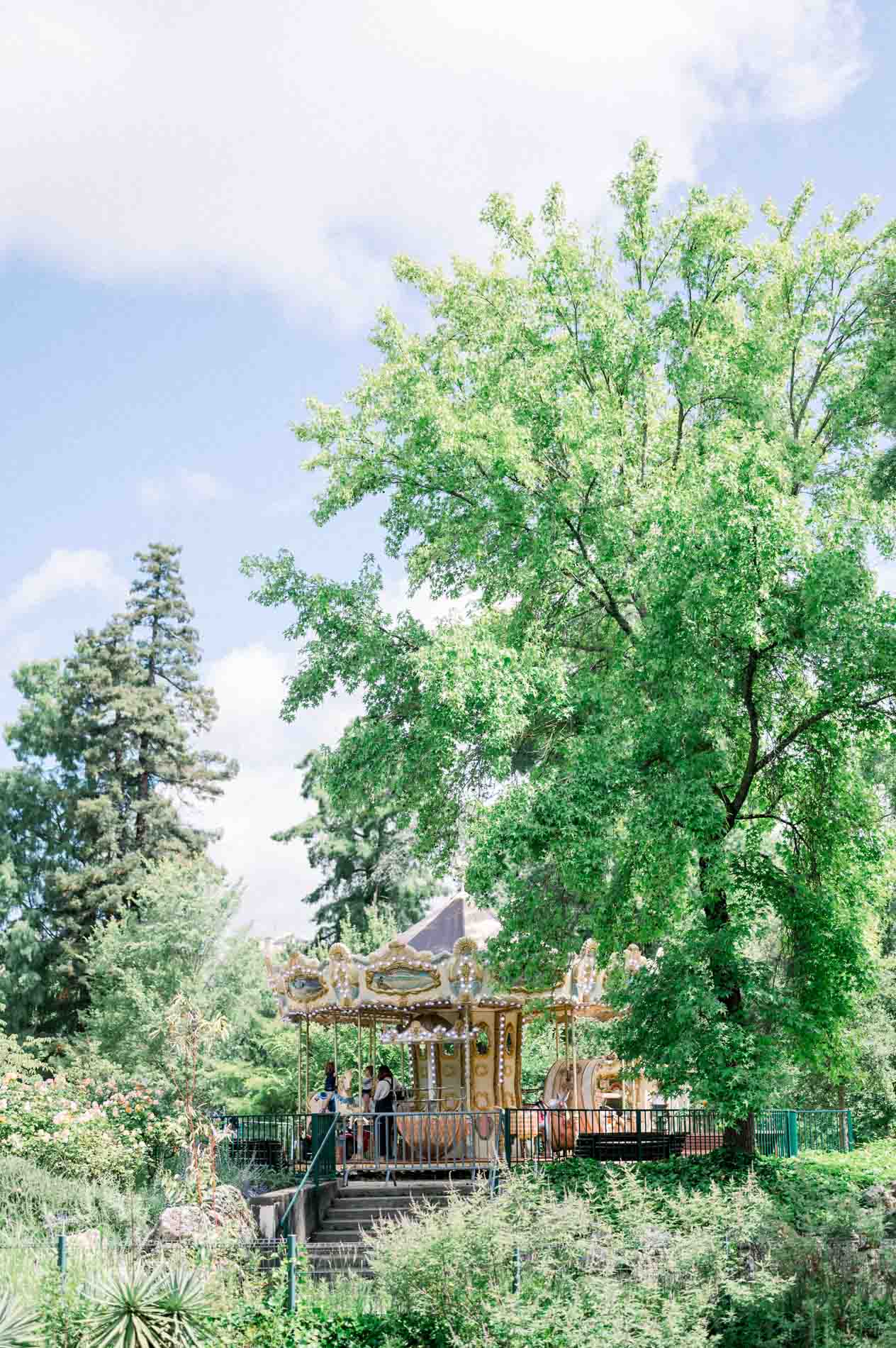 The vintage carousel of the Jardin Public among the trees