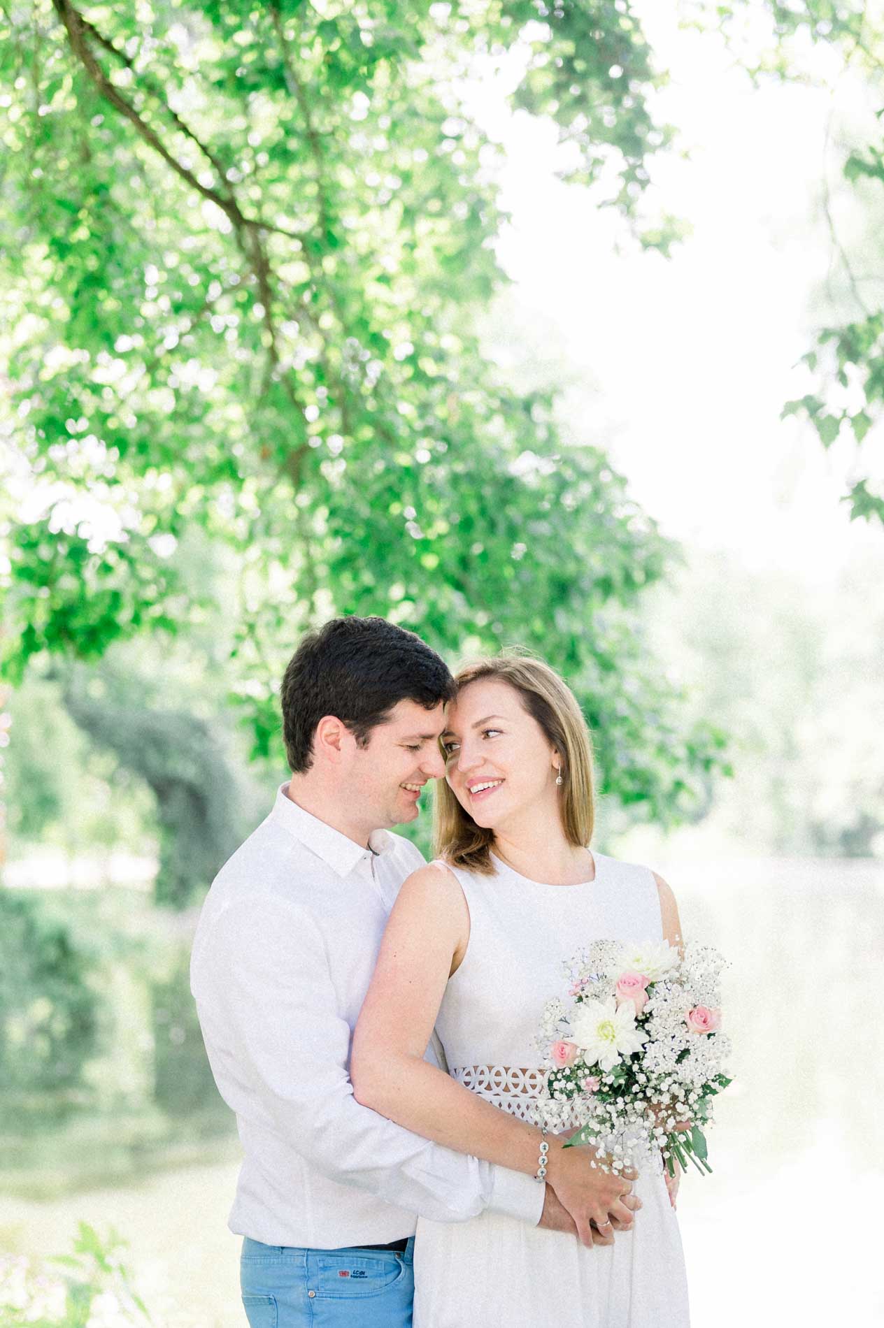 Tamara and Nicolas embracing cheek to cheek, bouquet in hand
