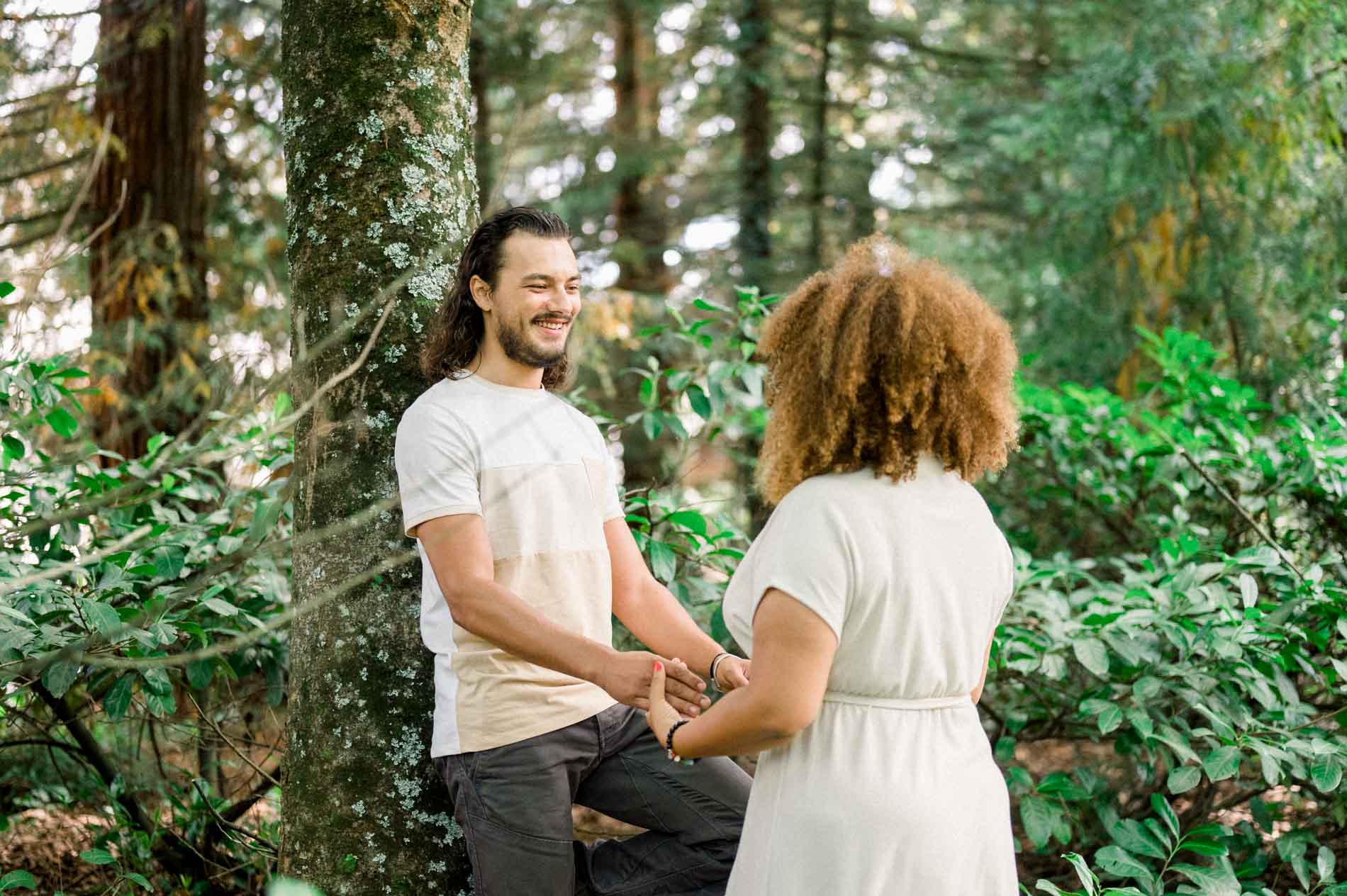 Couple holding hands face to face in the woodland