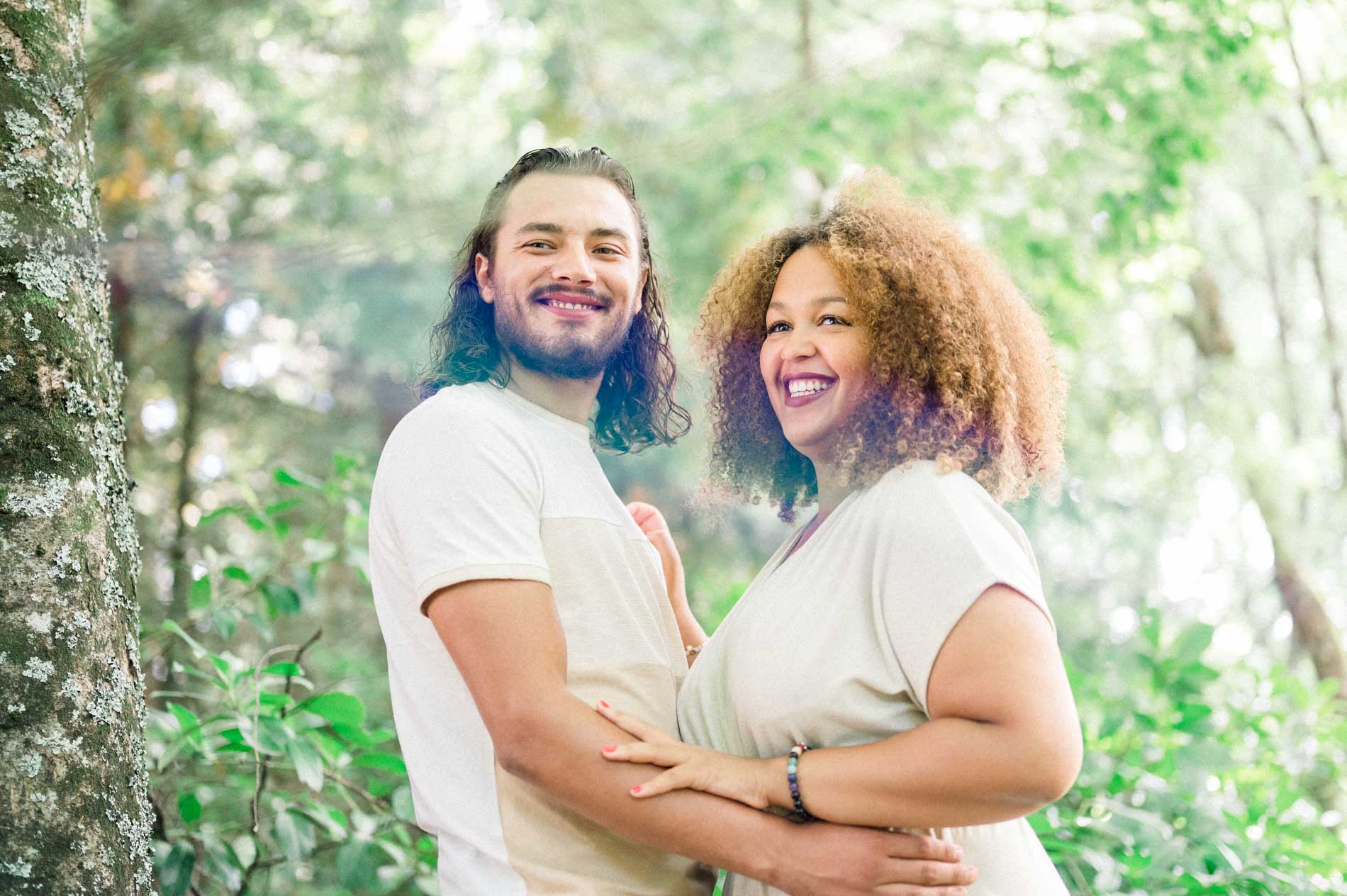 Smiling couple embracing against the foliage of the Parc Bordelais