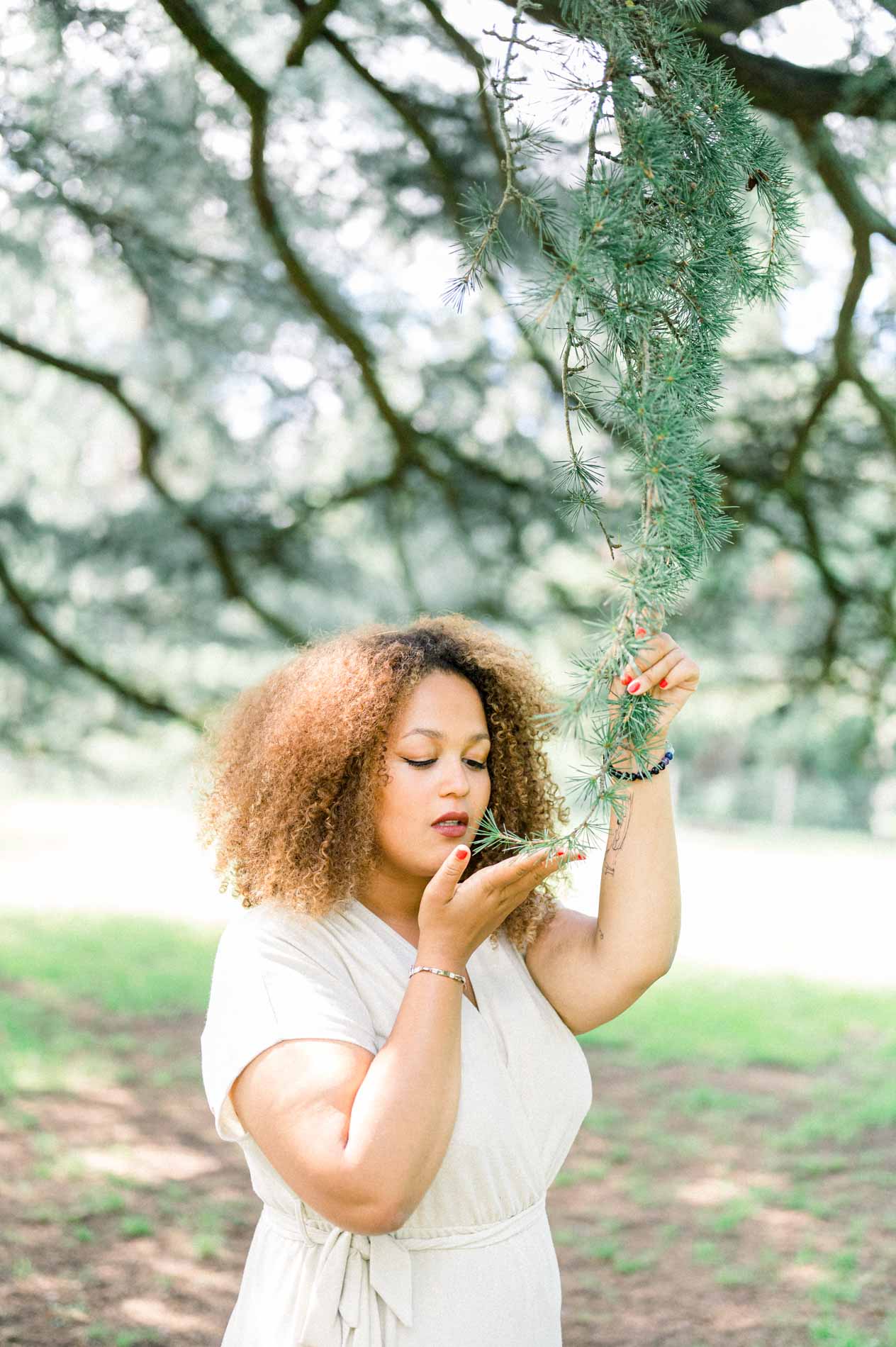 Young woman smelling a cedar branch with her eyes closed