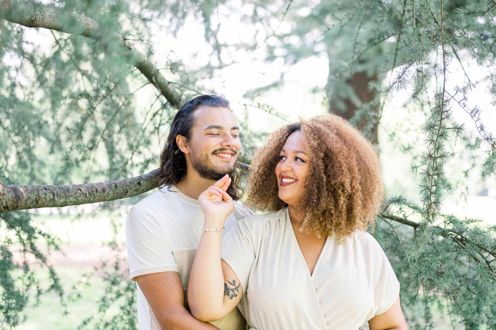 Young woman stroking her partner's beard as she laughs