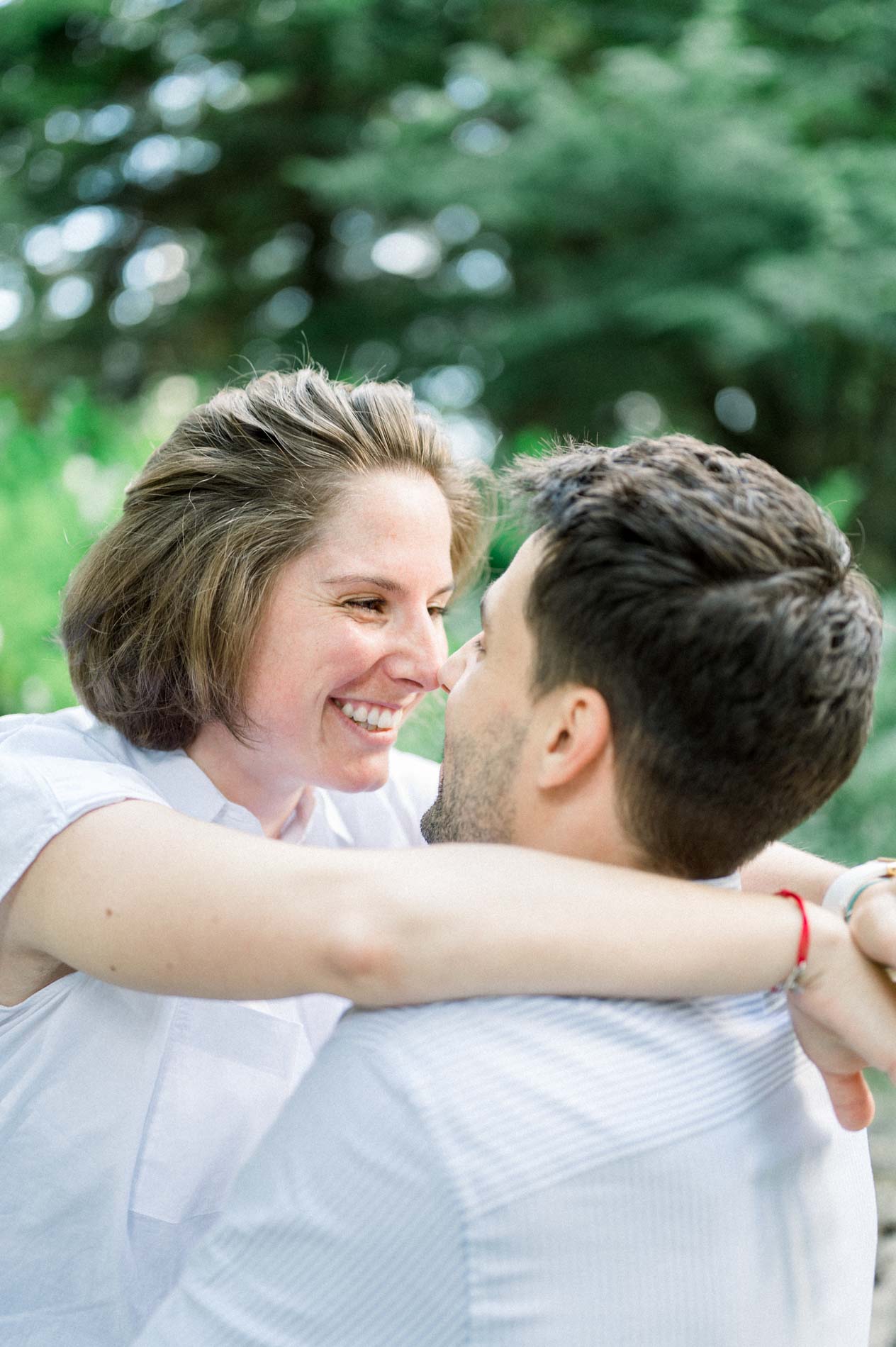 Mother-to-be laughing in her partner's arms