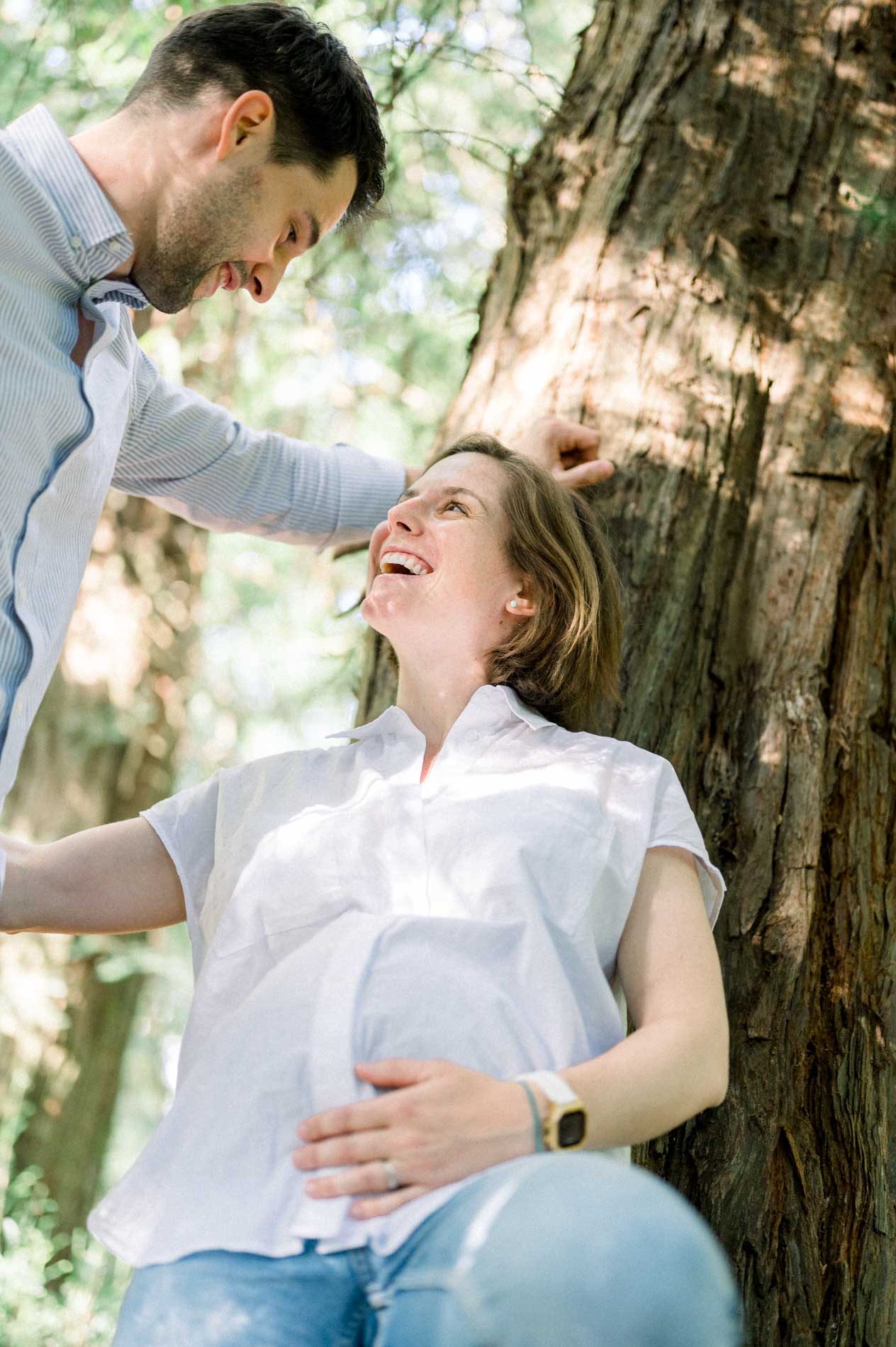 Smiling mother-to-be looking up at her partner leaning over her