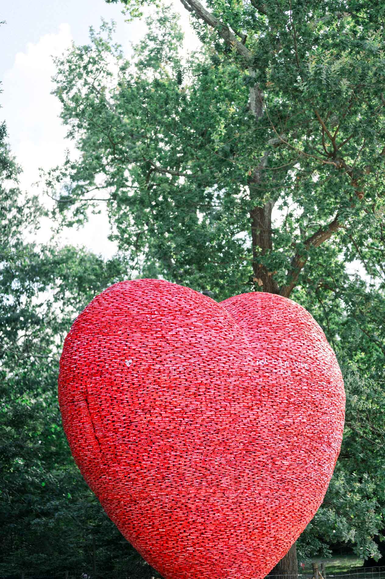 Large red heart sculpture in front of the trees of the Parc Bordelais