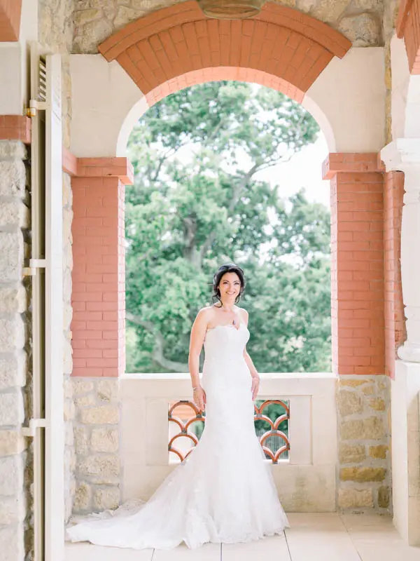 The bride in a mermaid gown under the brick arches of Villa la Tosca