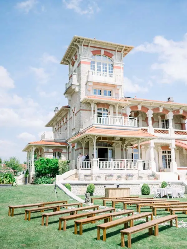 Wooden benches lined up on the lawn for the outdoor ceremony at the villa
