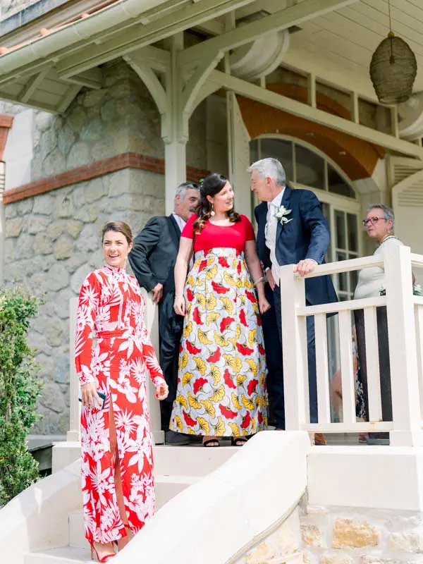 Bridesmaids in colourful dresses coming down the steps before the outdoor ceremony
