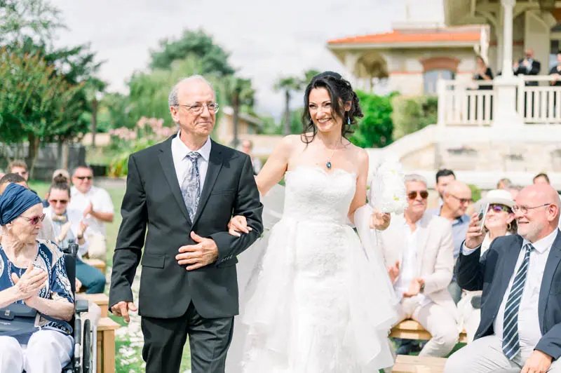 The bride walking down the aisle on the arm of a loved one
