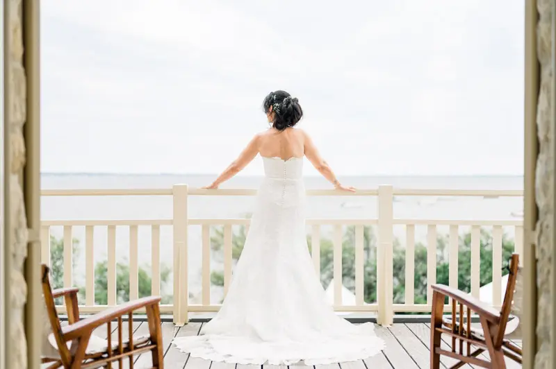 The bride seen from behind facing Arcachon Bay on the wooden deck
