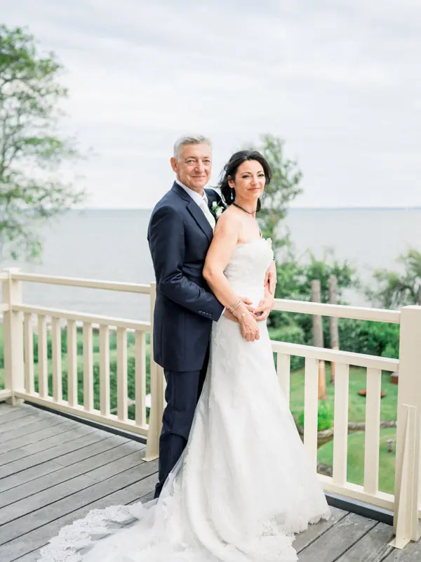 The couple embracing on the wooden deck overlooking Arcachon Bay