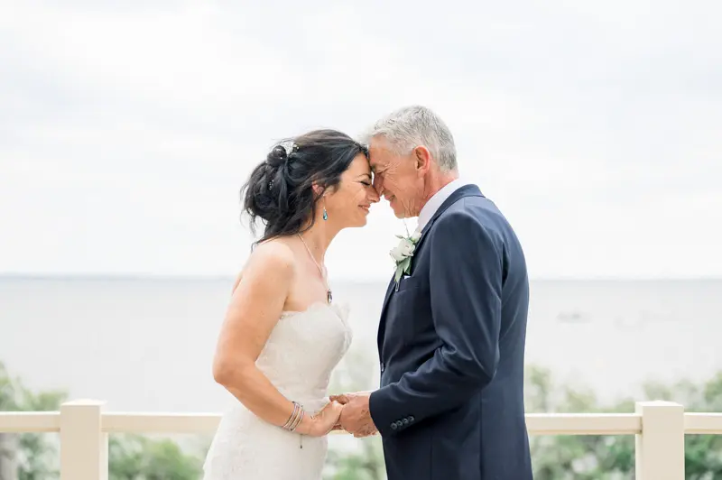 The bride and groom forehead to forehead by Arcachon Bay