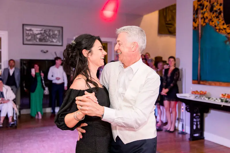 The bride and groom dancing joyfully as guests look on