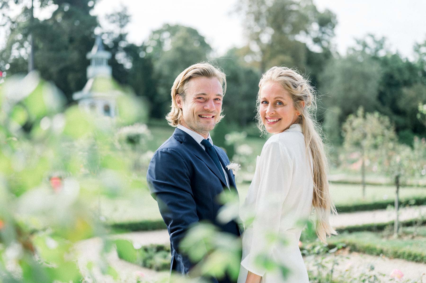 Virginie and Victor smiling at each other in the gardens of Parc de Bagatelle