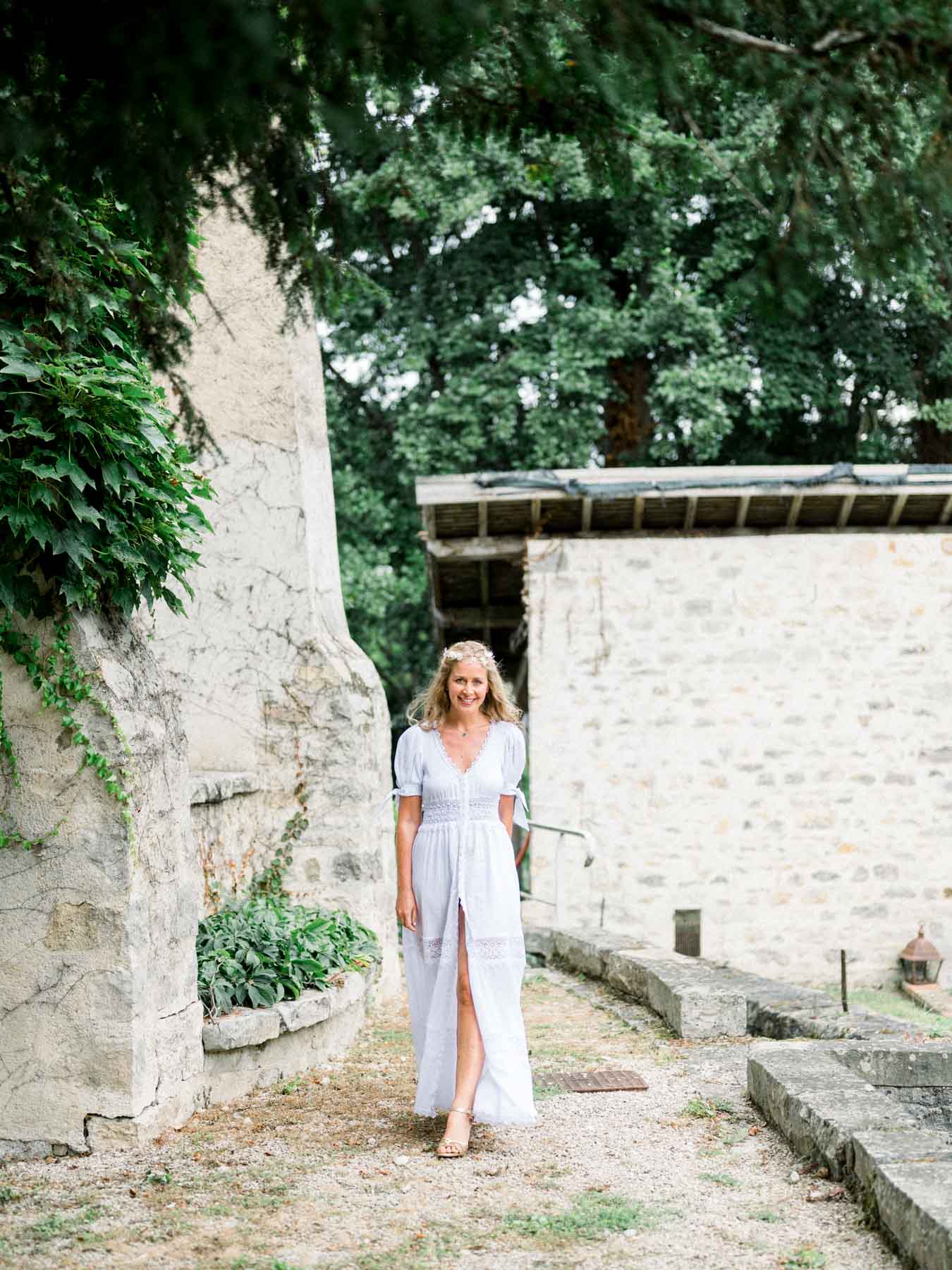 The bride walking between the stone walls of the mill courtyard