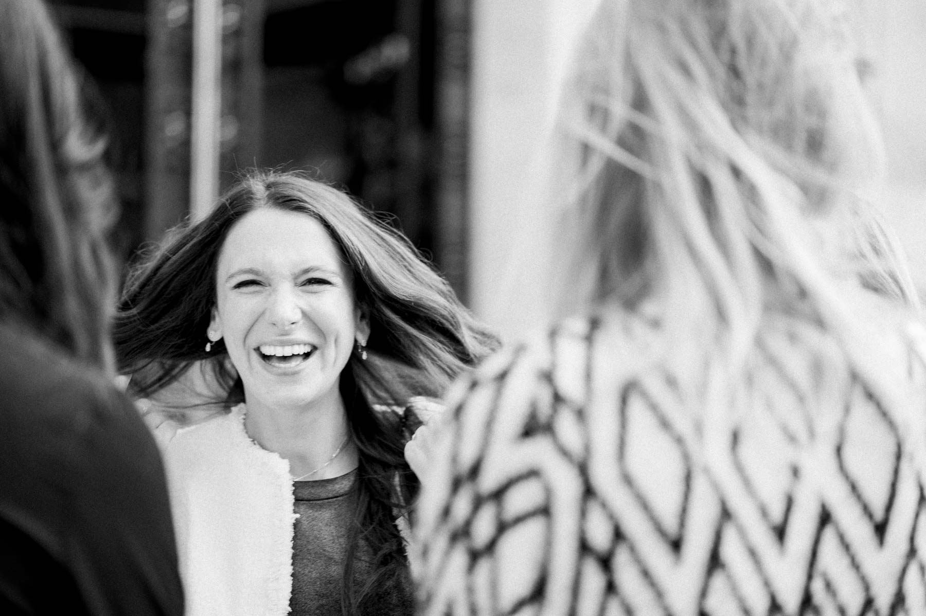A guest bursting into laughter outside the town hall, in black and white