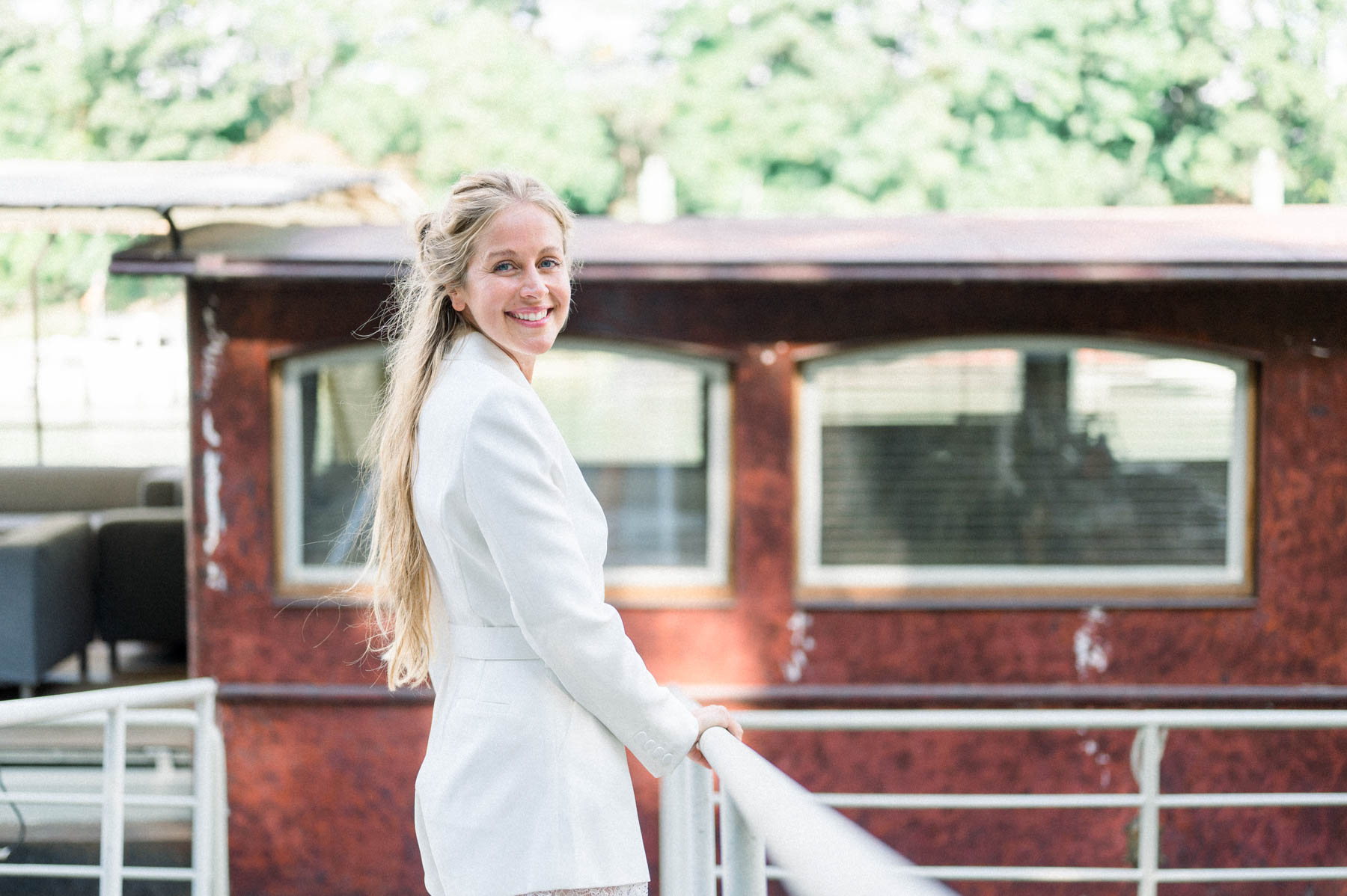 The bride smiling on the deck of a red barge moored on the Seine
