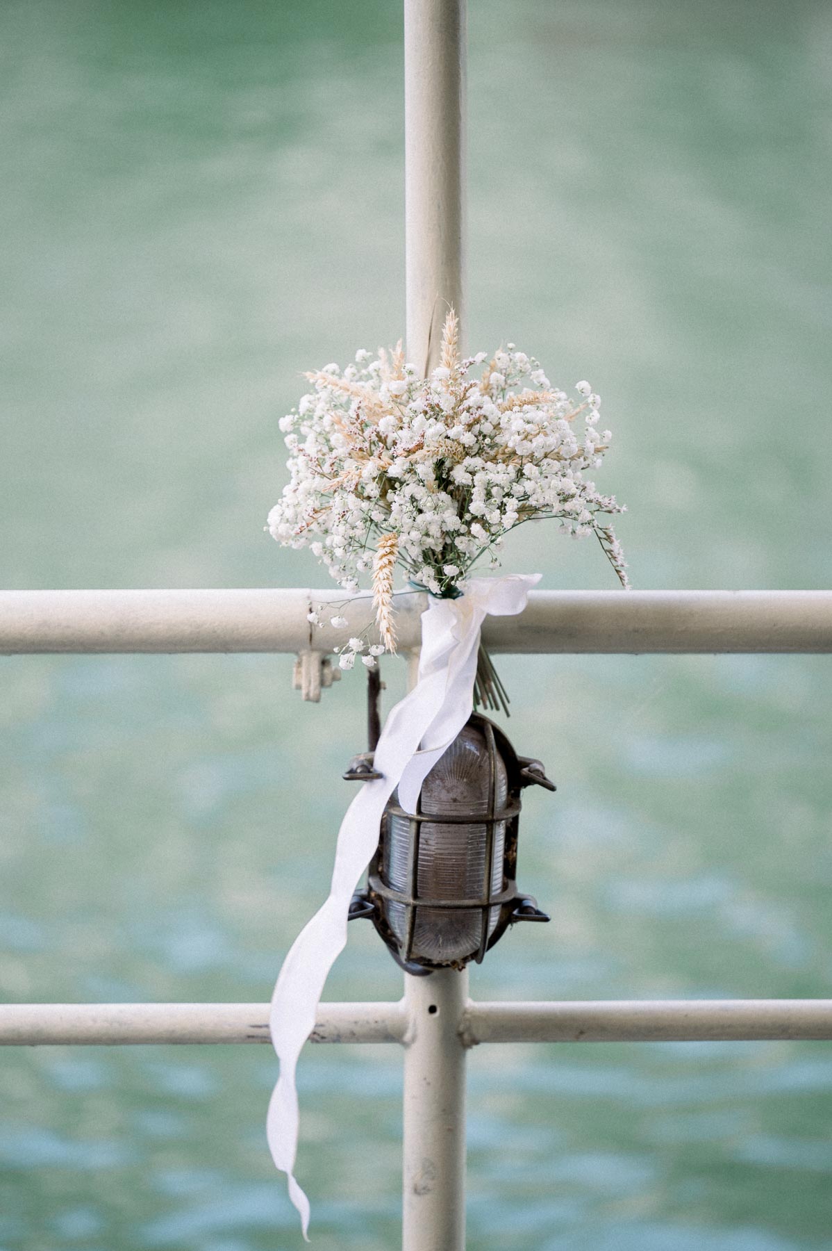 Gypsophila posy and lantern tied to the barge railing above the Seine