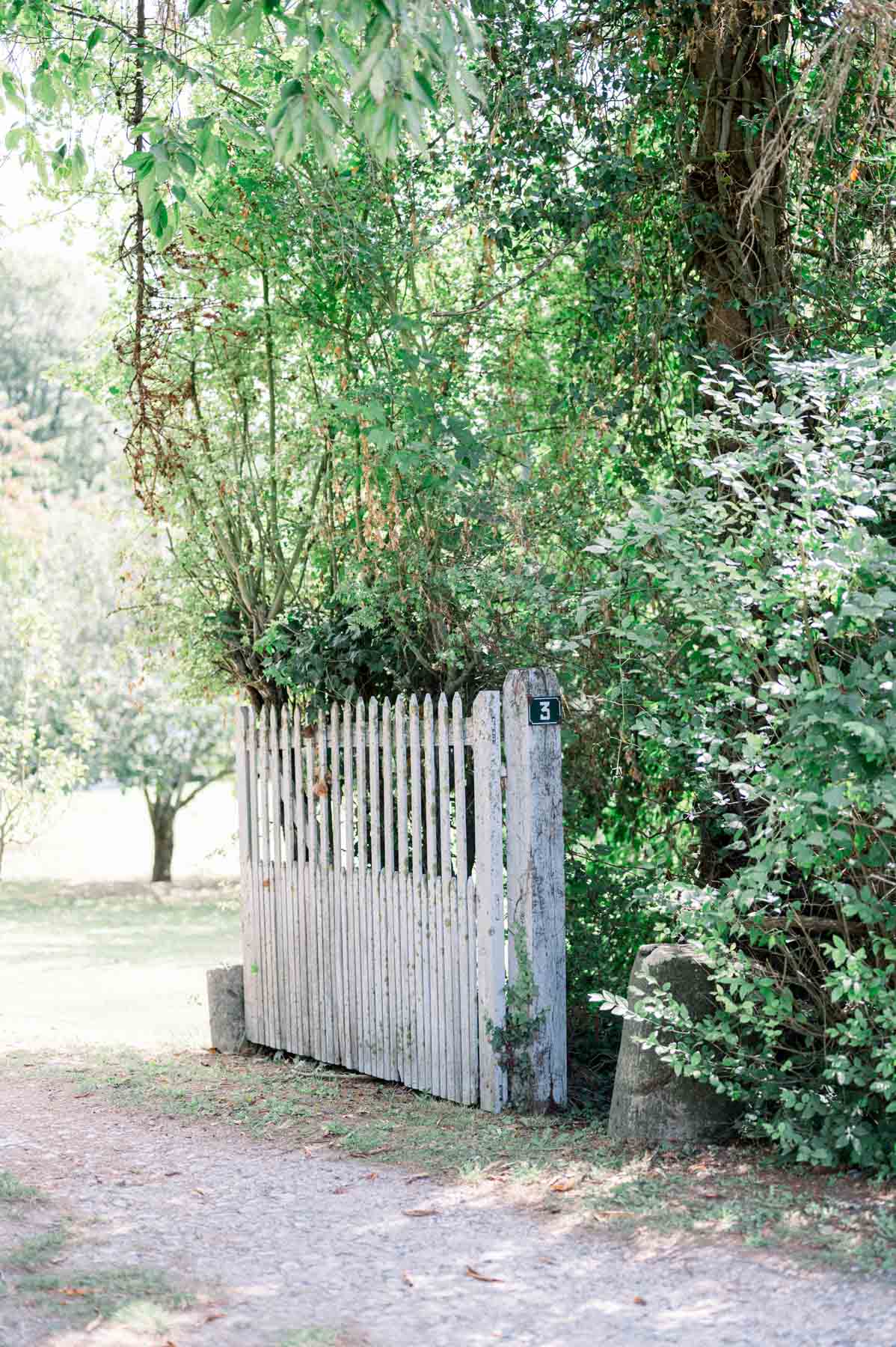 Weathered wooden gate beneath the trees at the entrance to Moulin de Launoy