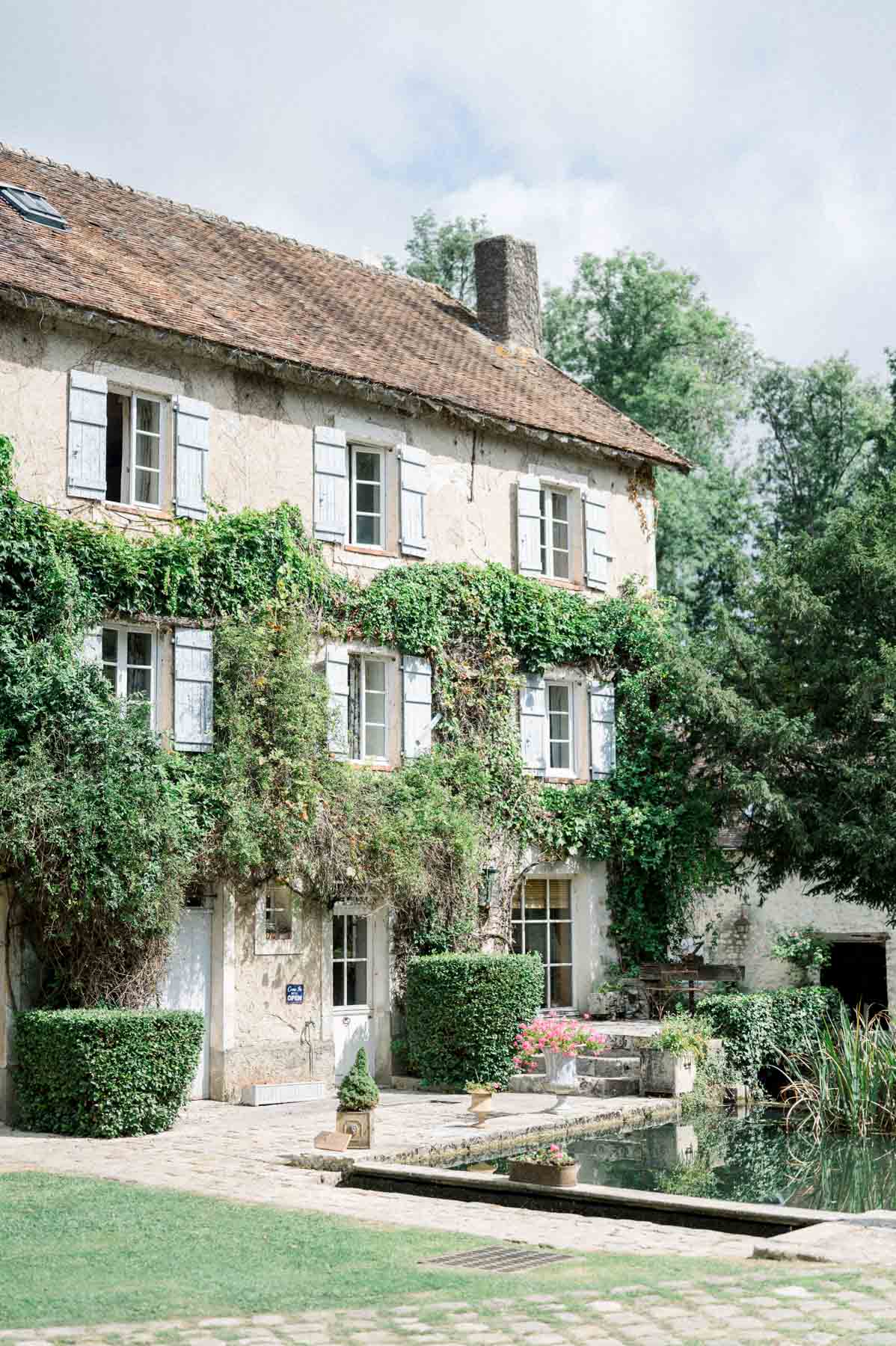 Ivy-covered stone mill house by the water at Moulin de Launoy