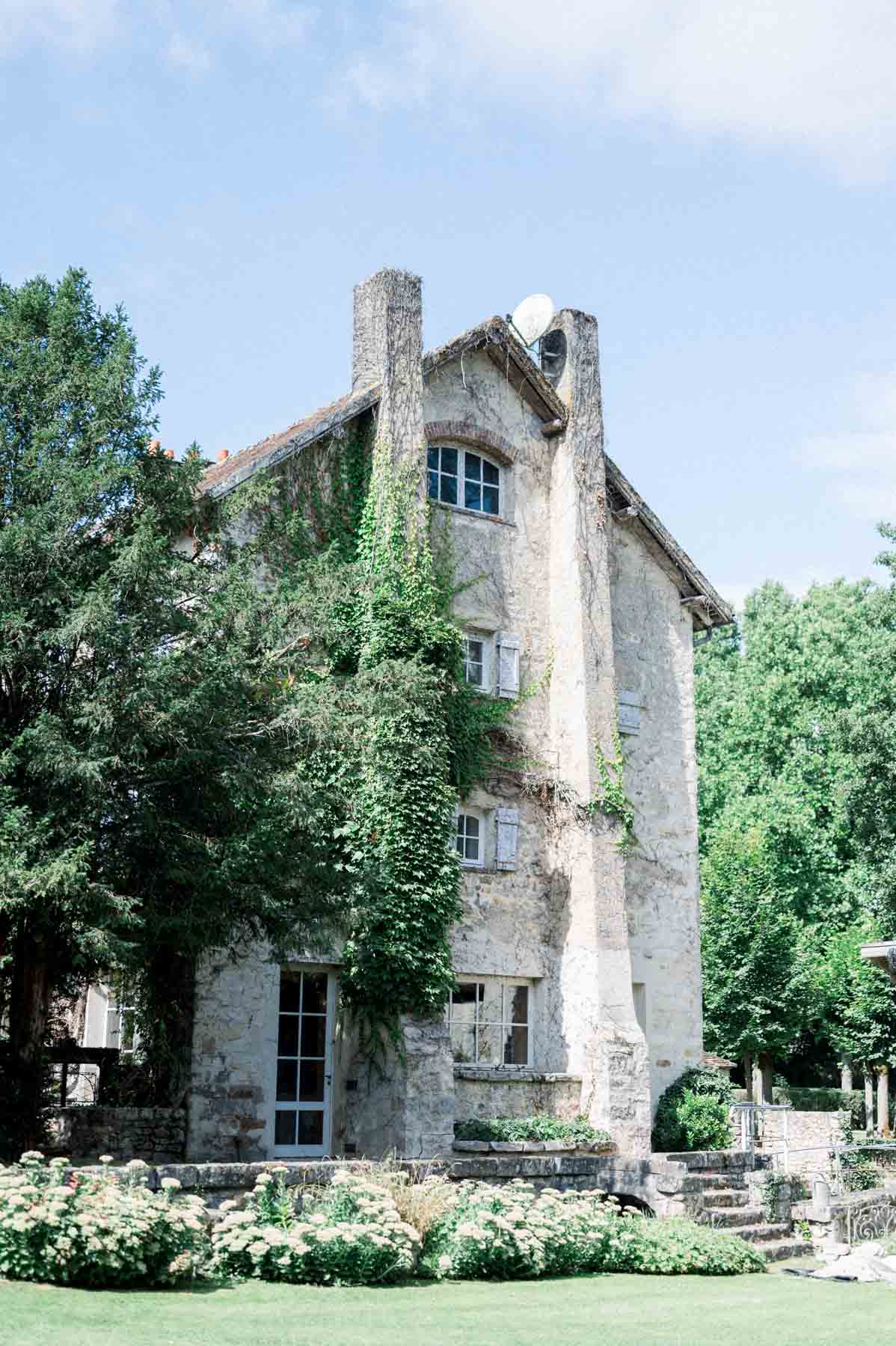 Ivy-covered stone tower and rose bed at Moulin de Launoy