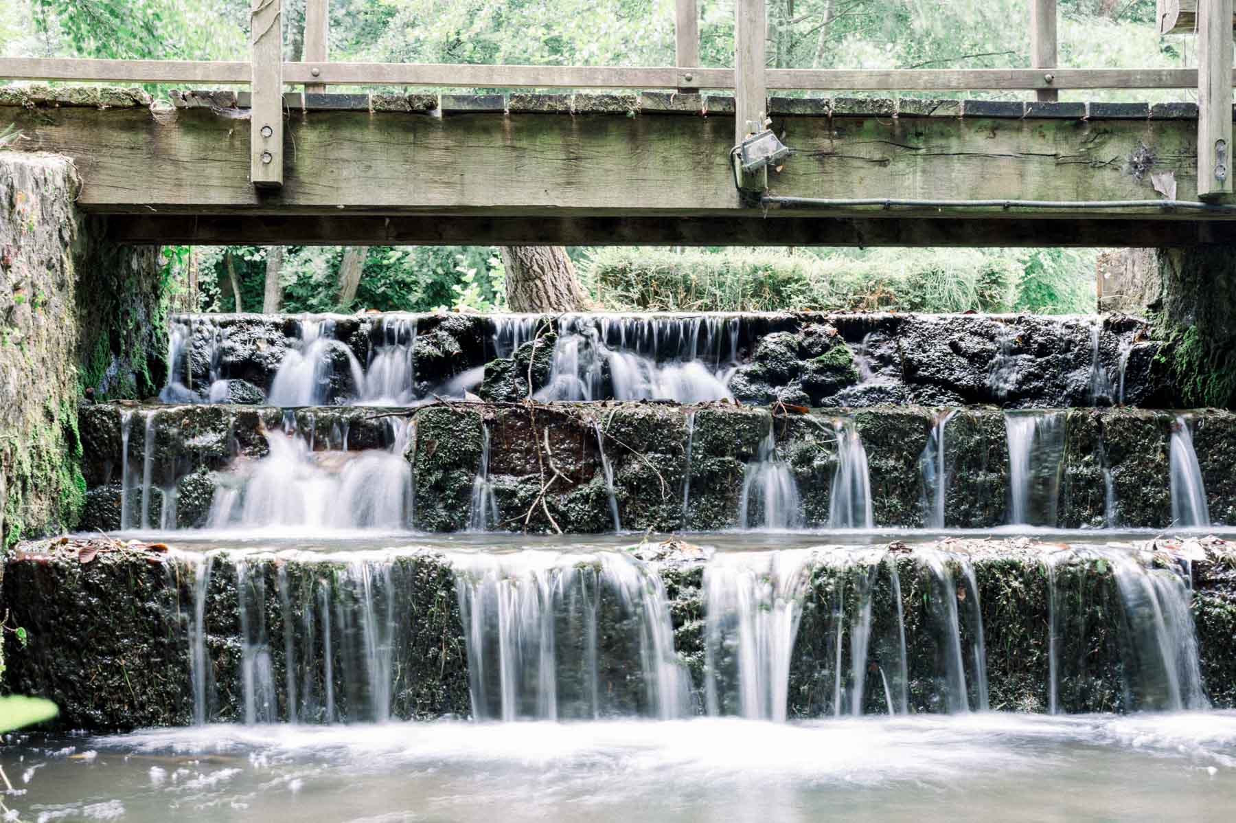 Wooden bridge over the cascading mill race at Moulin de Launoy