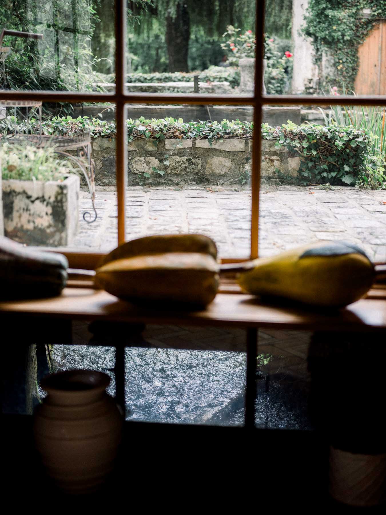 Gourds resting on a windowsill overlooking the stone courtyard