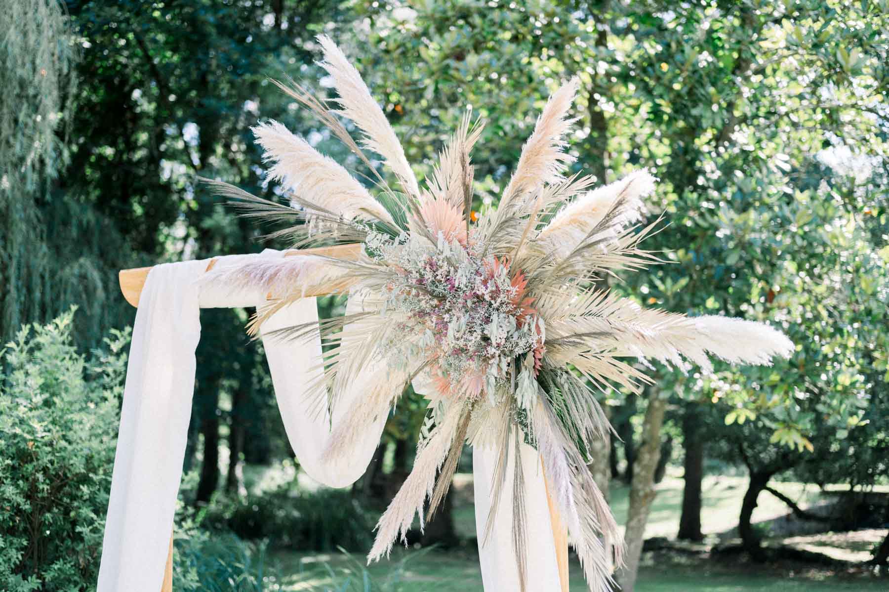 Pampas grass and dried-flower arrangement on top of the ceremony arch
