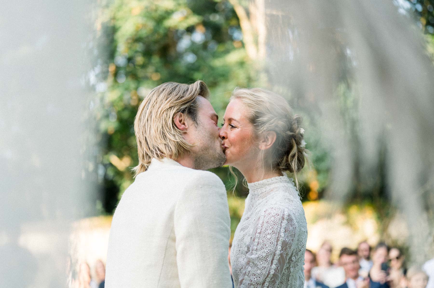 The couple's first kiss during the outdoor ceremony, in front of the guests