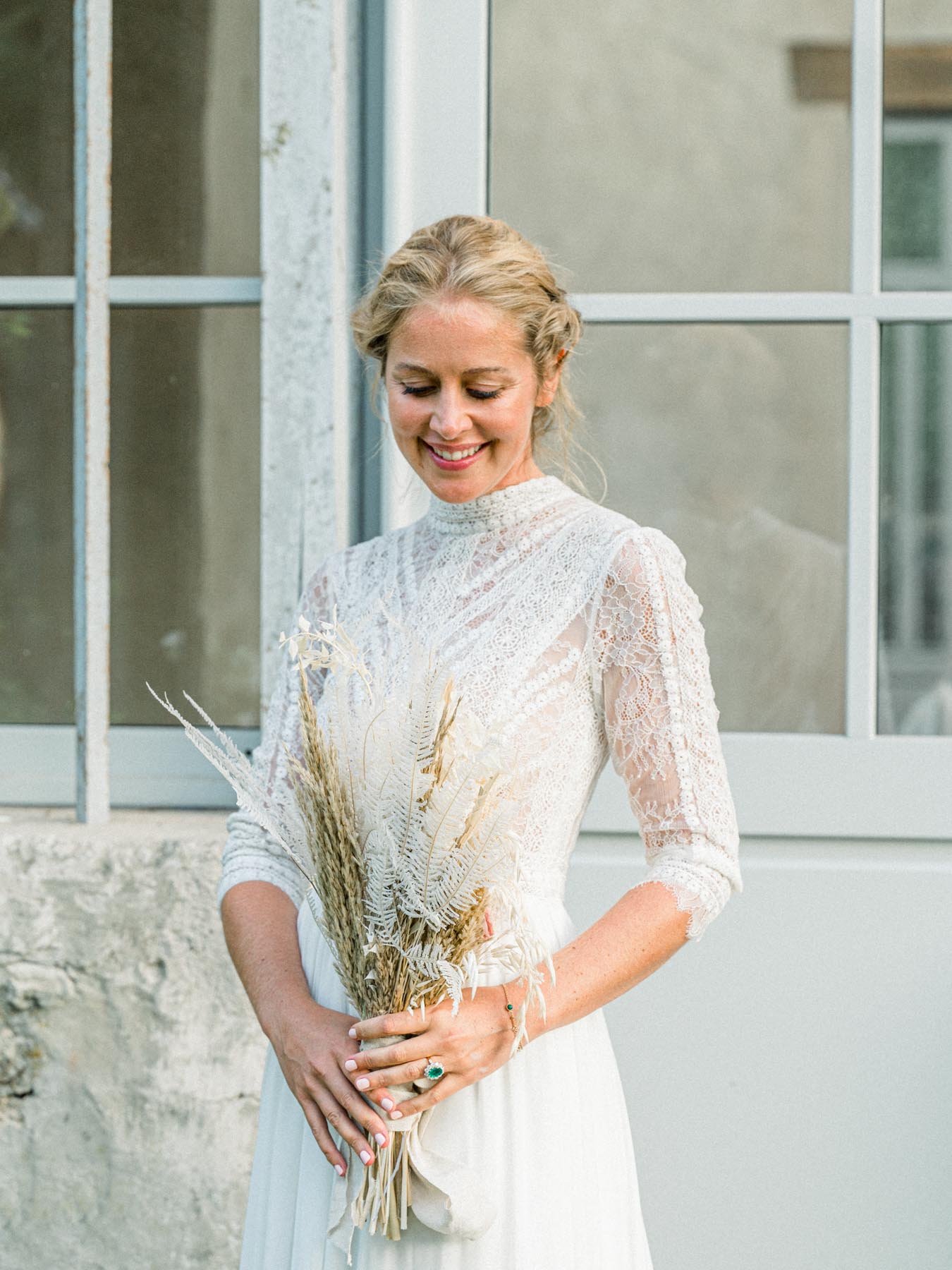 Portrait of the smiling bride holding a dried-flower bouquet
