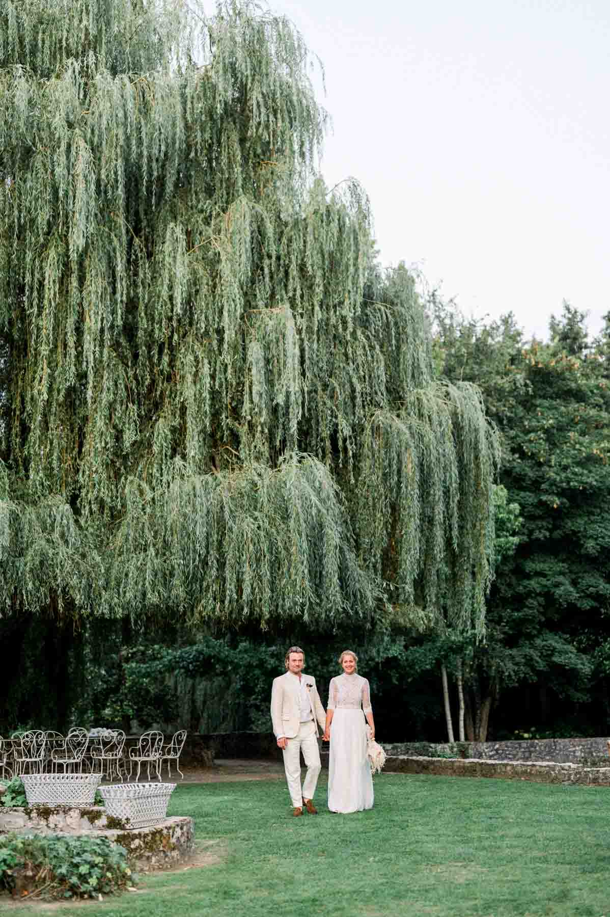 The couple dwarfed by a huge weeping willow at Moulin de Launoy