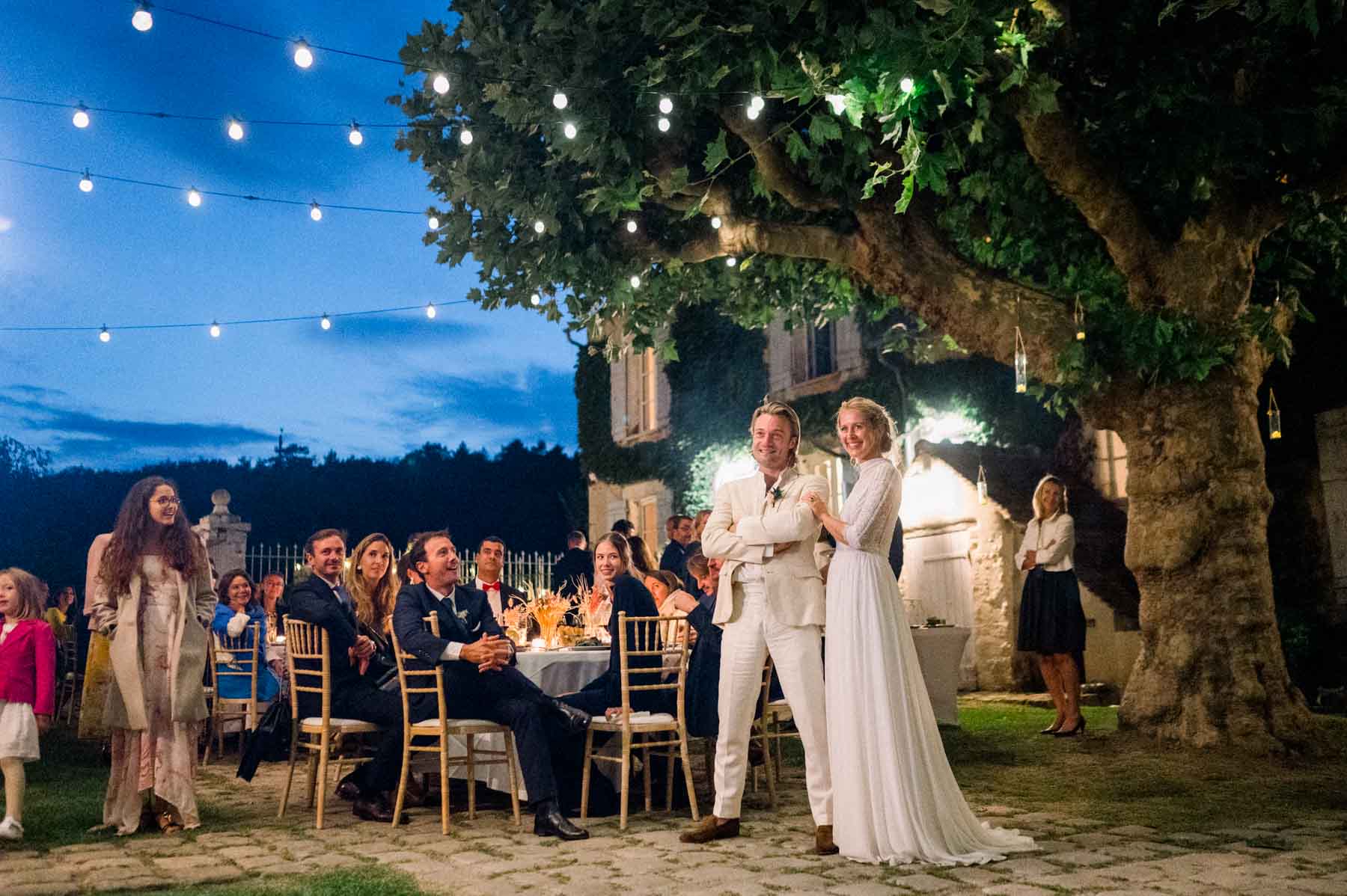 Wedding dinner at blue hour beneath string lights at Moulin de Launoy