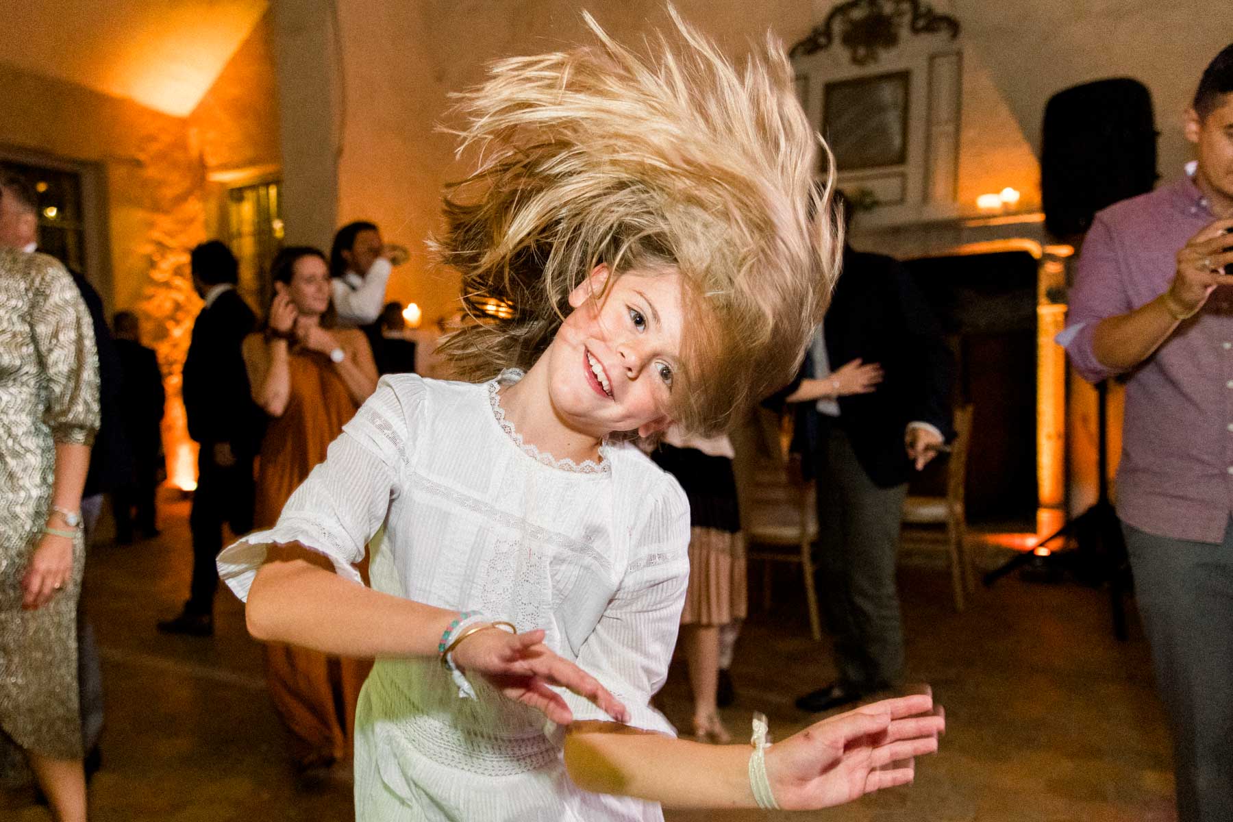 A guest dancing and tossing her blonde hair on the dance floor