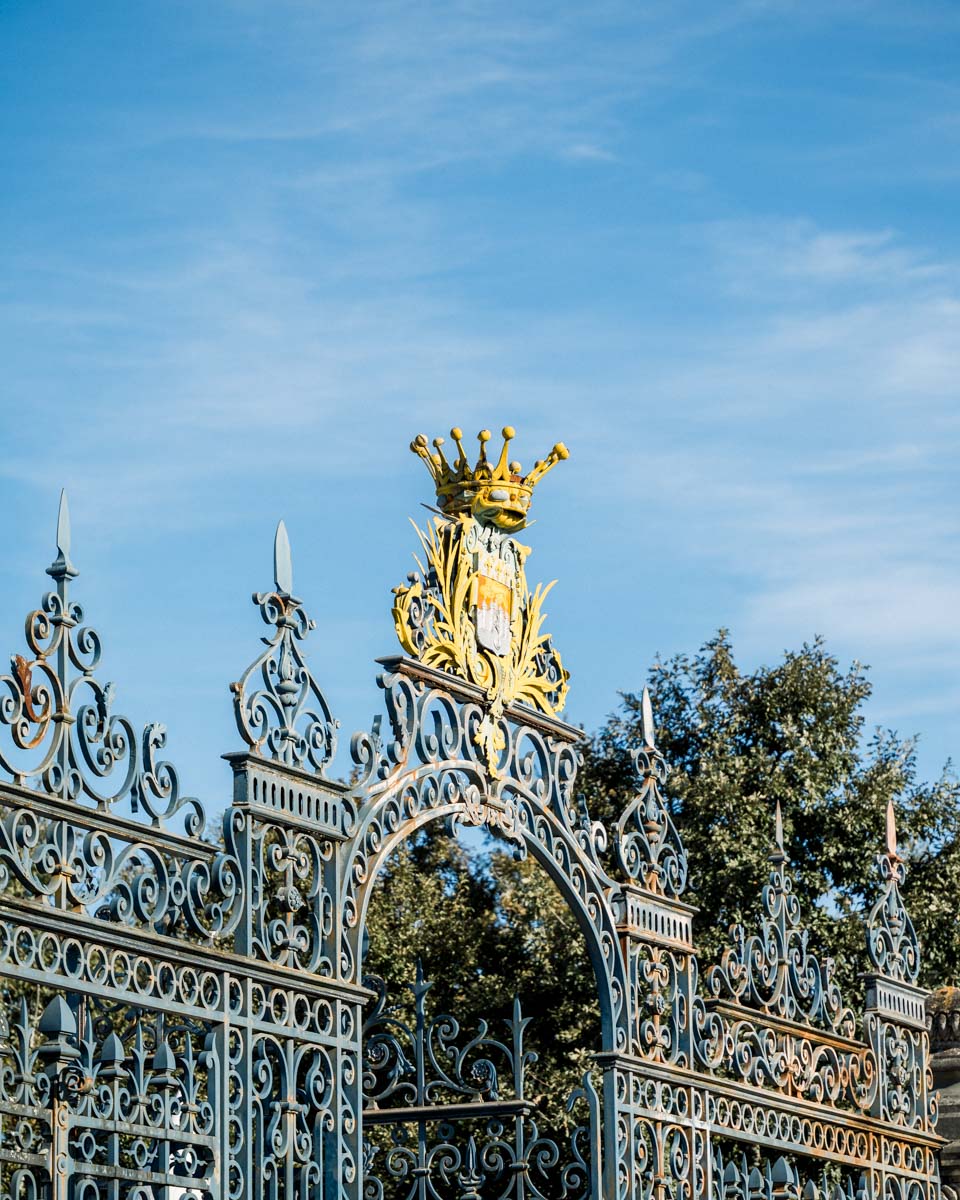 Gilded wrought-iron entrance gate of Parc Bordelais under a blue sky