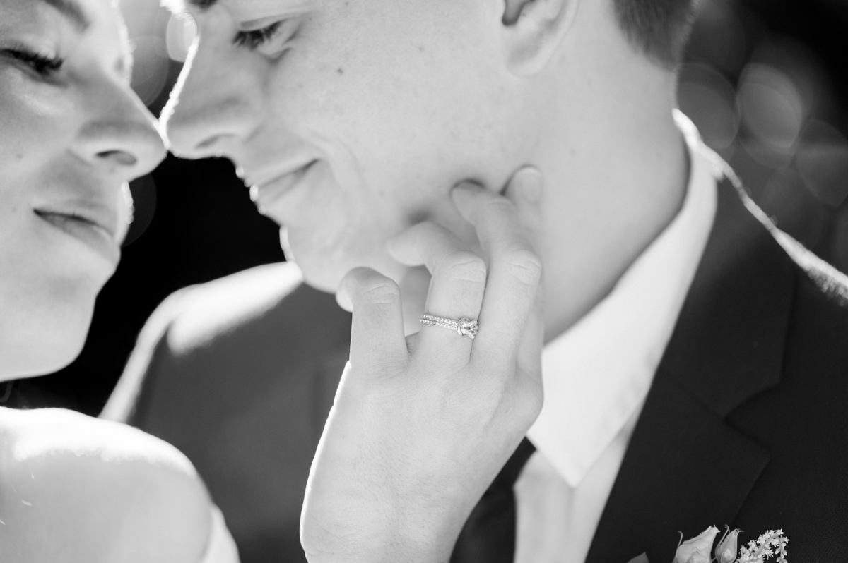 She touches her partner's face, ring on her finger, in black and white