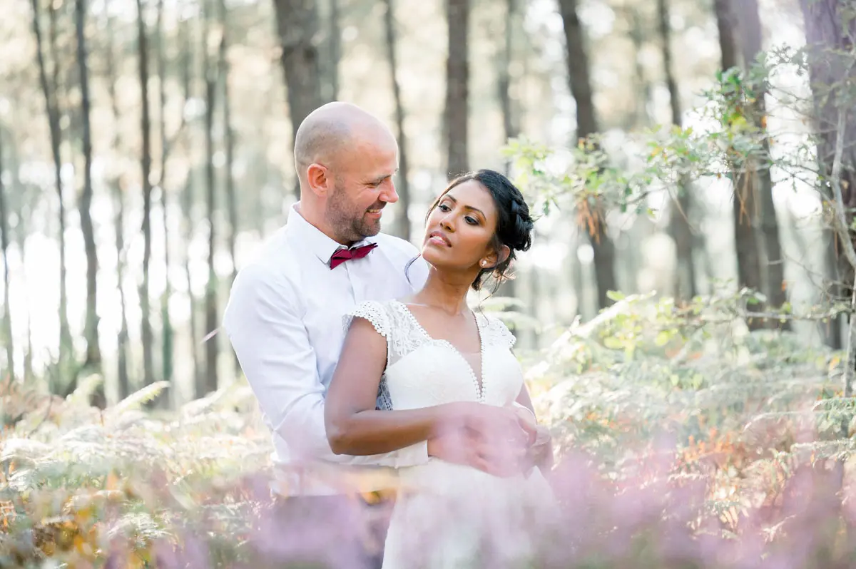 Bride and groom embracing in a pine forest with heather, Balizac wedding