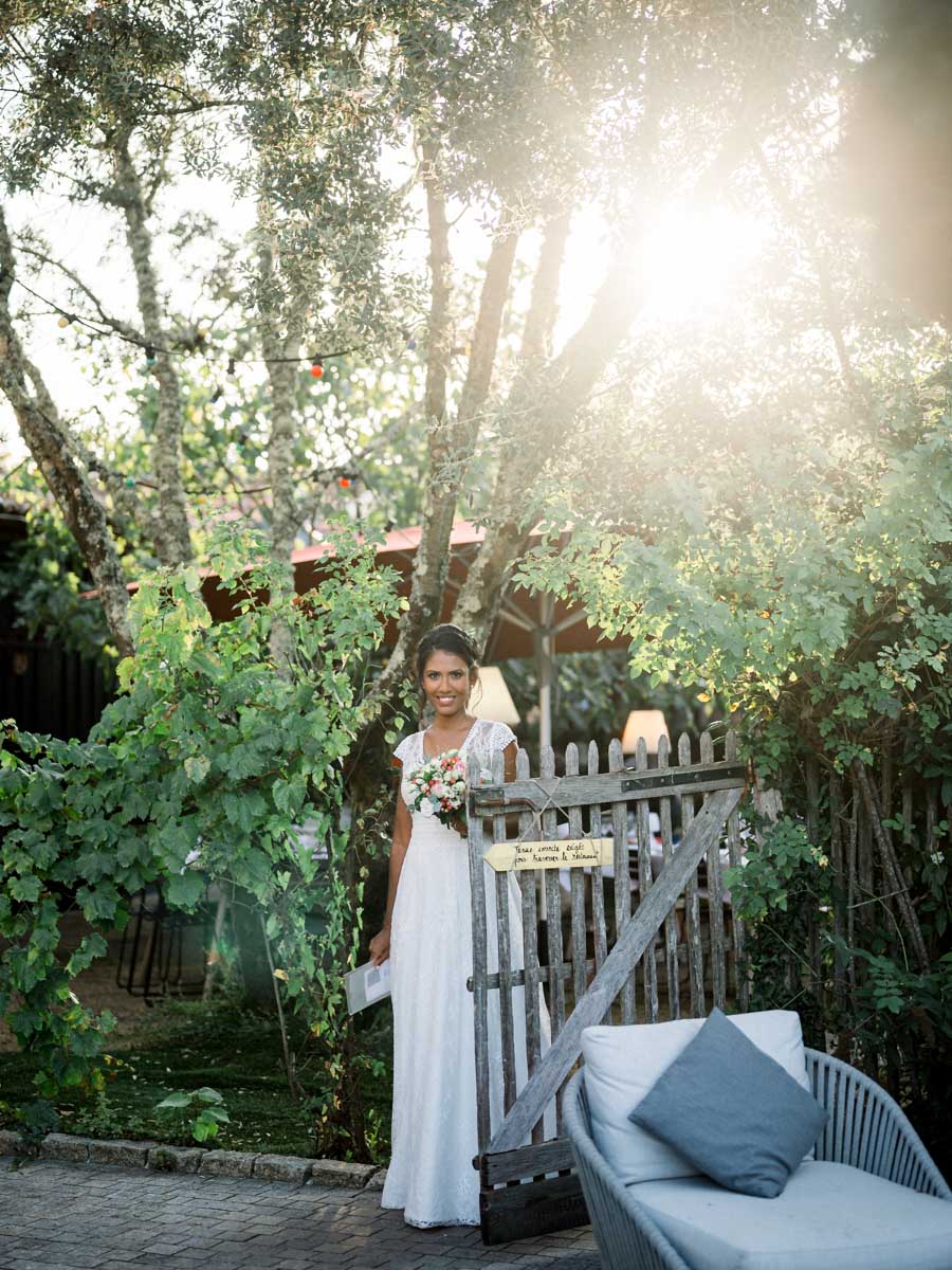 The bride at the garden gate bathed in sunlight at Le Résinier
