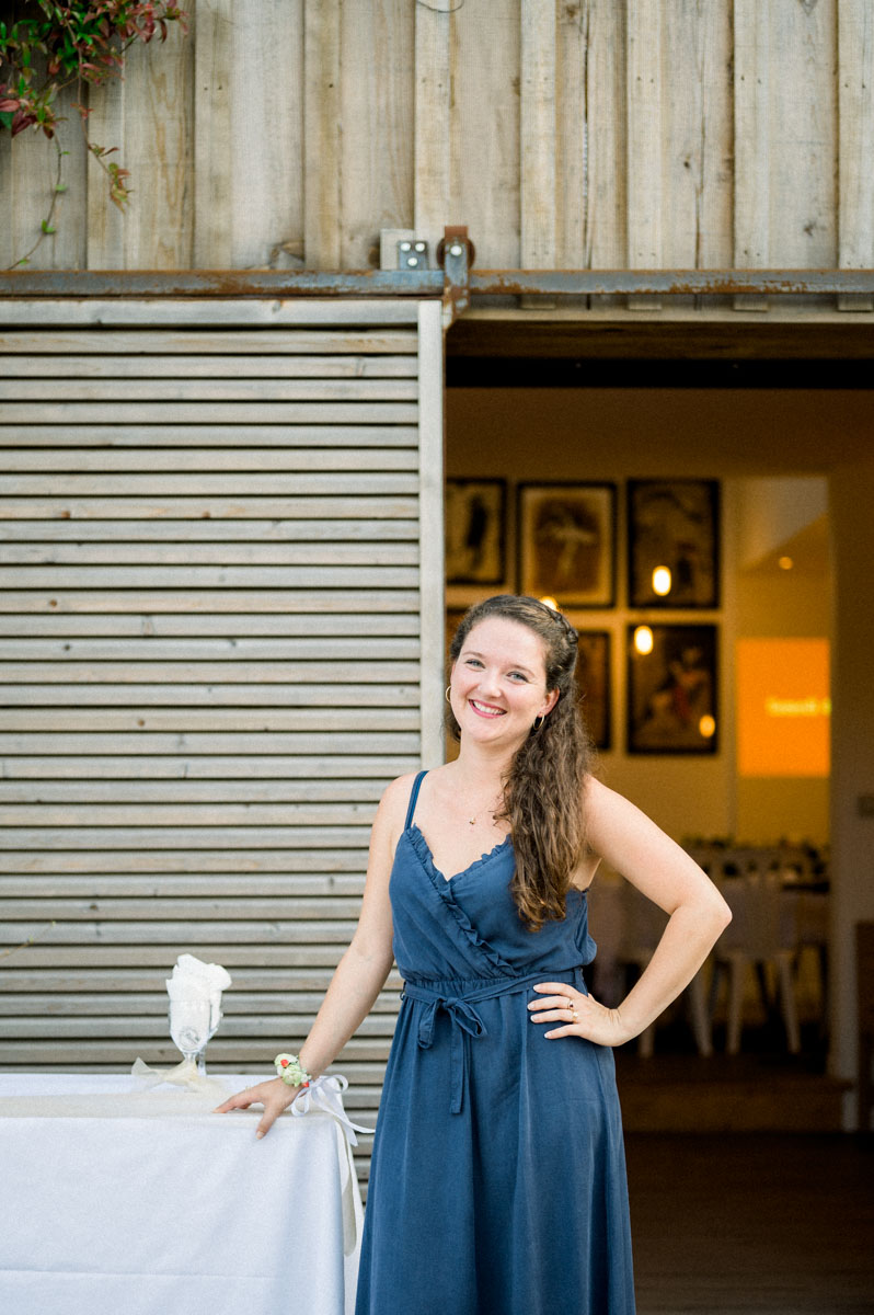 A smiling woman in a blue dress on a doorstep at Le Résinier