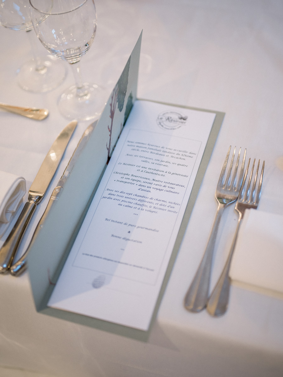 Wedding menu card laid on the set table between the cutlery