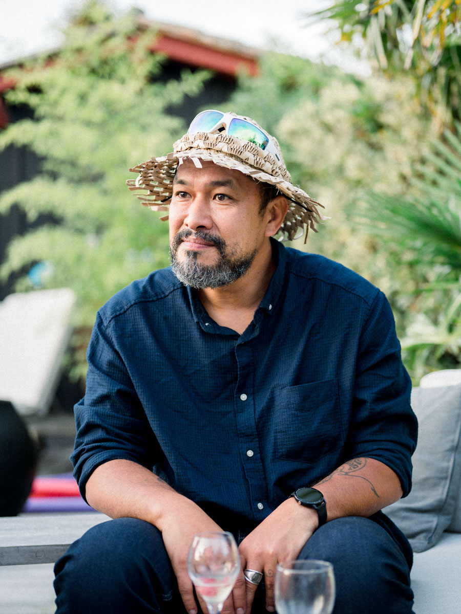 Guest in a colourful bucket hat seated on a sofa during the drinks