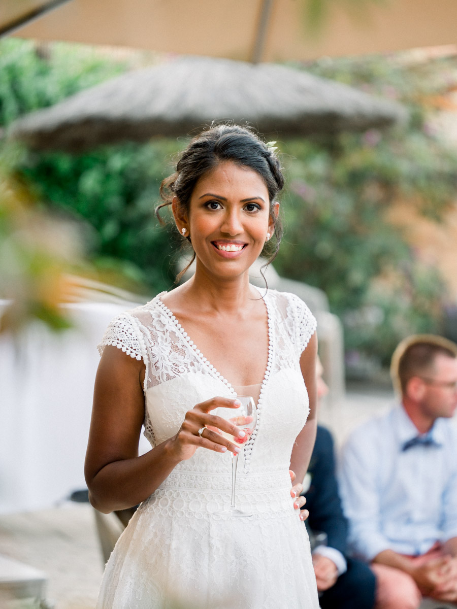 The smiling bride holding a glass of rosé during the drinks at Le Résinier