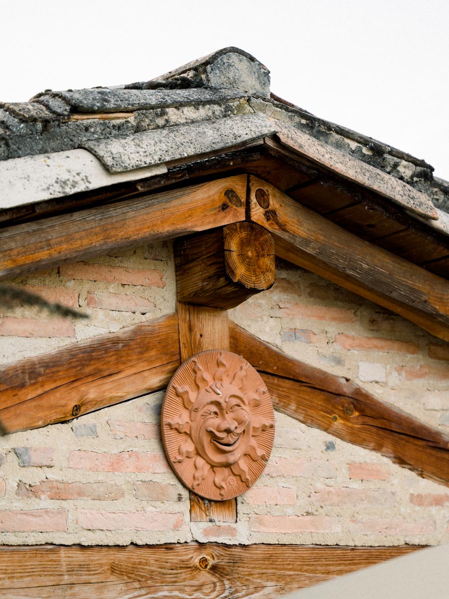 Terracotta sun beneath a tiled, half-timbered gable at Le Résinier