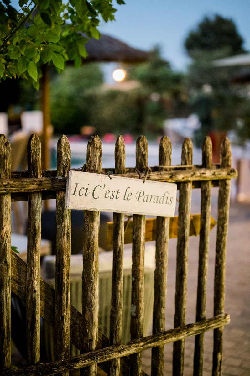 Wooden fence and "Ici c'est le Paradis" sign at dusk