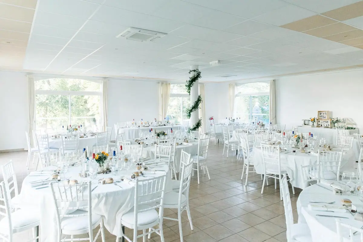 Reception hall at Château Courtade-Dubuc set with white round tables