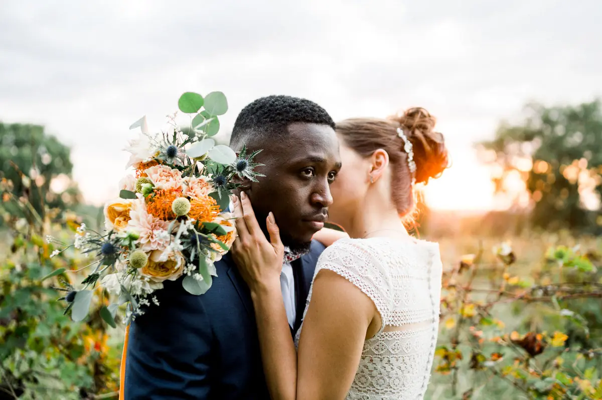 The bride nestled against the groom, bouquet resting on his shoulder